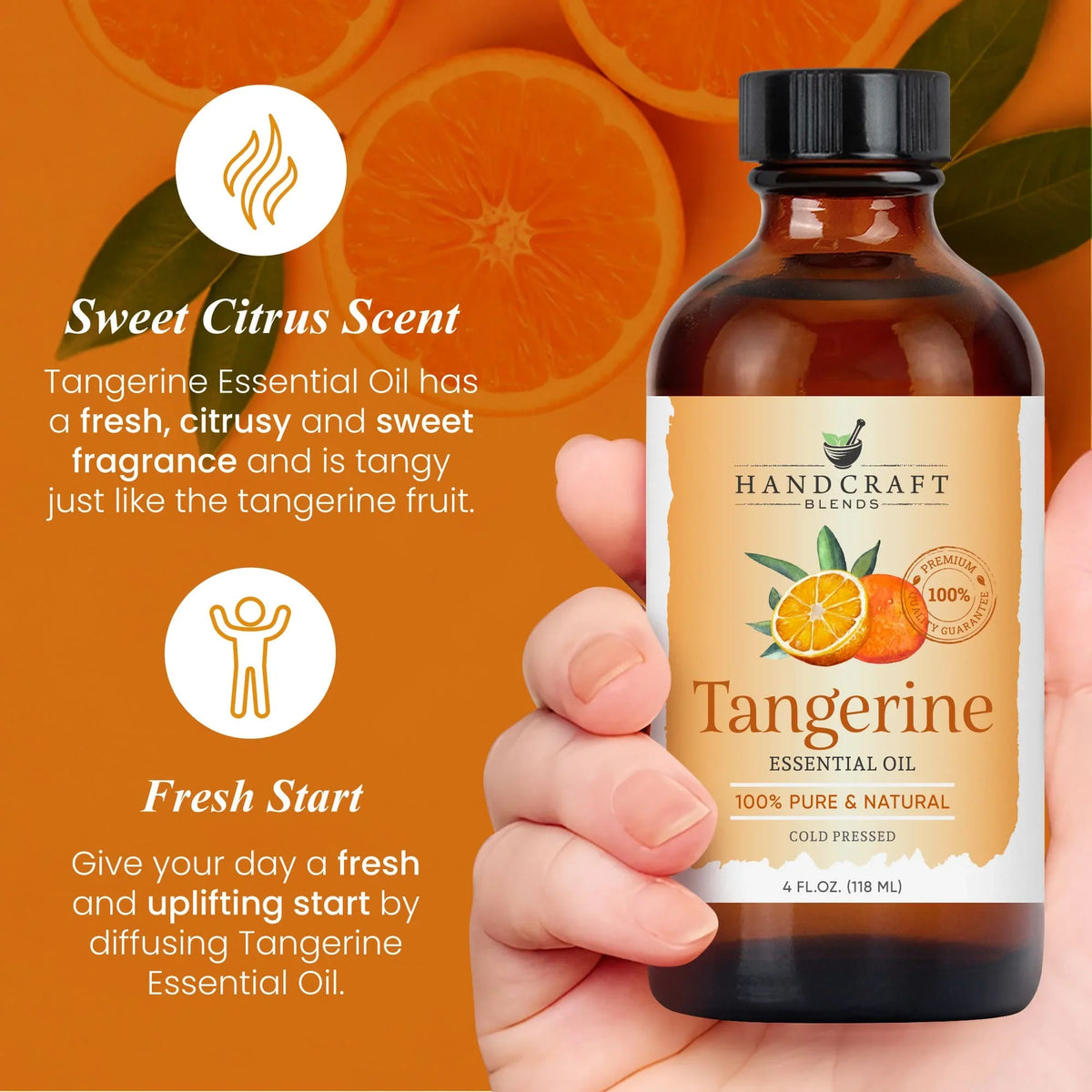 Hand holding a 4oz amber bottle of tangerine essential oil with sliced tangerines on orange background