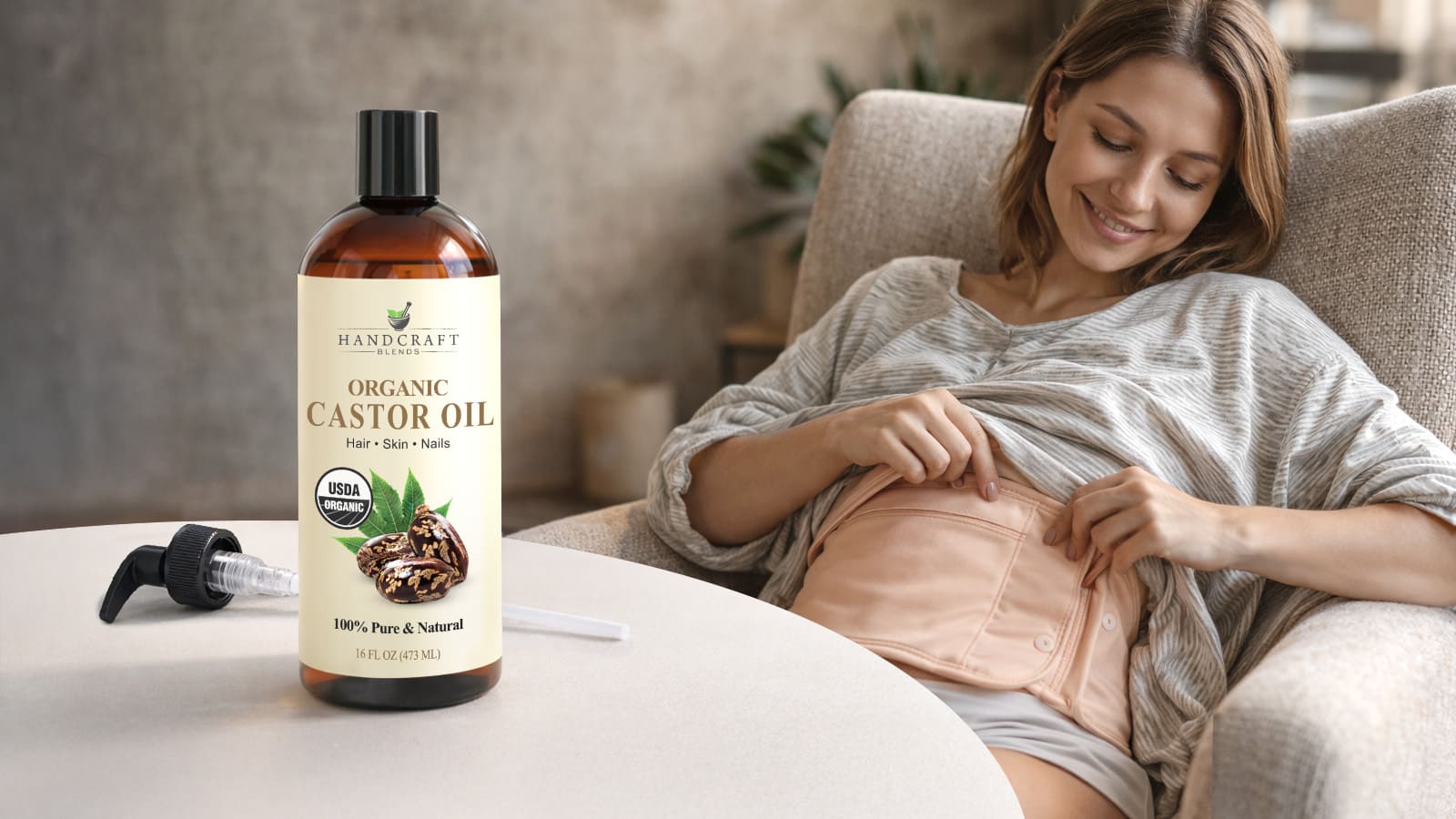 Woman using a beige castor oil wrap on abdomen, organic castor oil bottle in foreground.