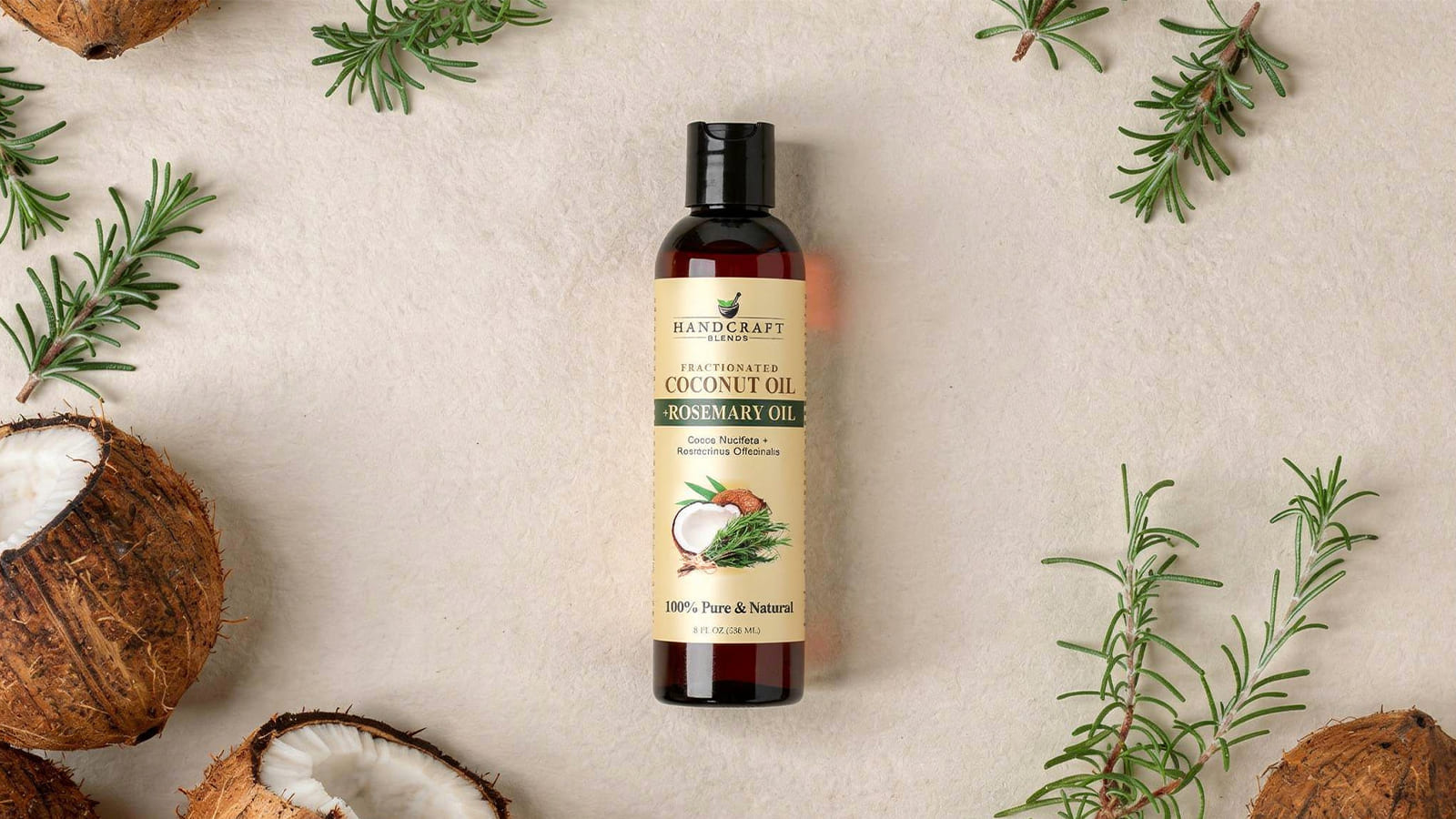Coconut rosemary oil bottle with coconut halves and fresh rosemary sprigs on beige background