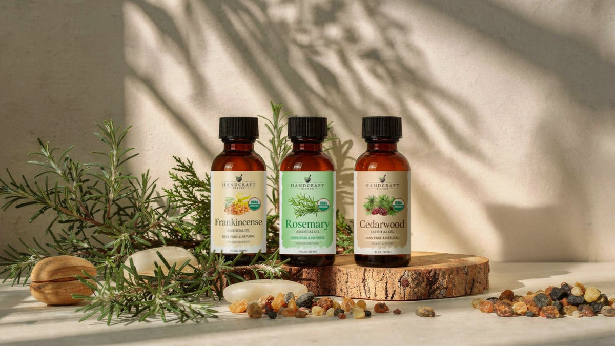 Bottles of patchouli and cedarwood essential oil next to dried herbs and wood shavings